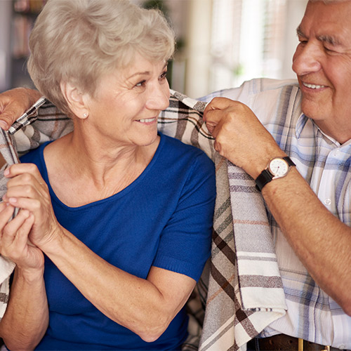 Couple keeping warm in home with space heater