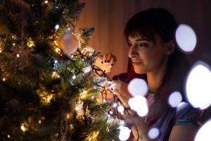 woman hanging ornaments on a Christmas tree